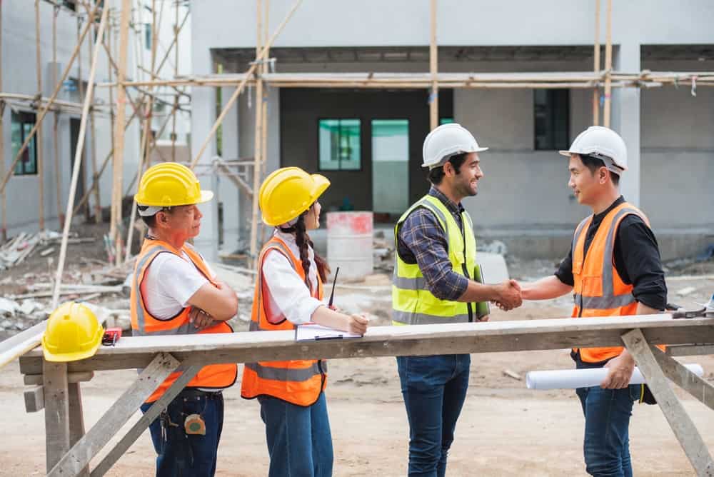 Smiling Engineer Shaking Hands At Construction Site